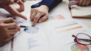 Advisors pointing to pie charts and KPI reports while reviewing an advisory practice valuation